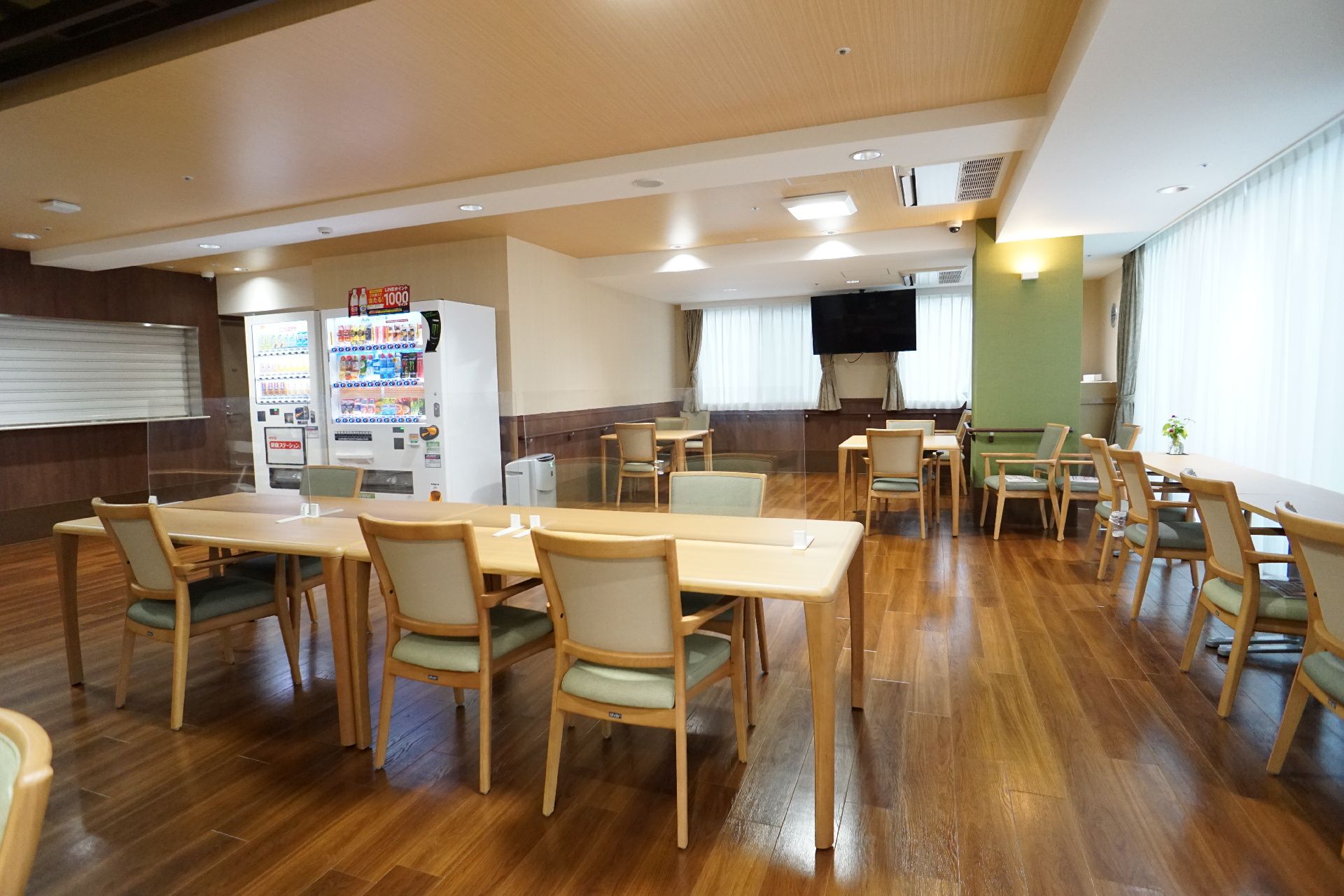 窓から日差しが差し込み、天井に照明が設置されている共有スペース