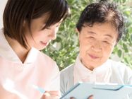 女性ケアマネジャーの話を聞く高齢女性