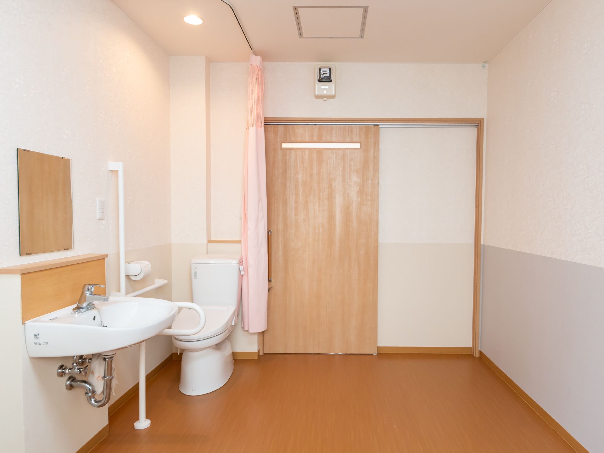 洗面台と洋式便器が置かれた白い壁の部屋
