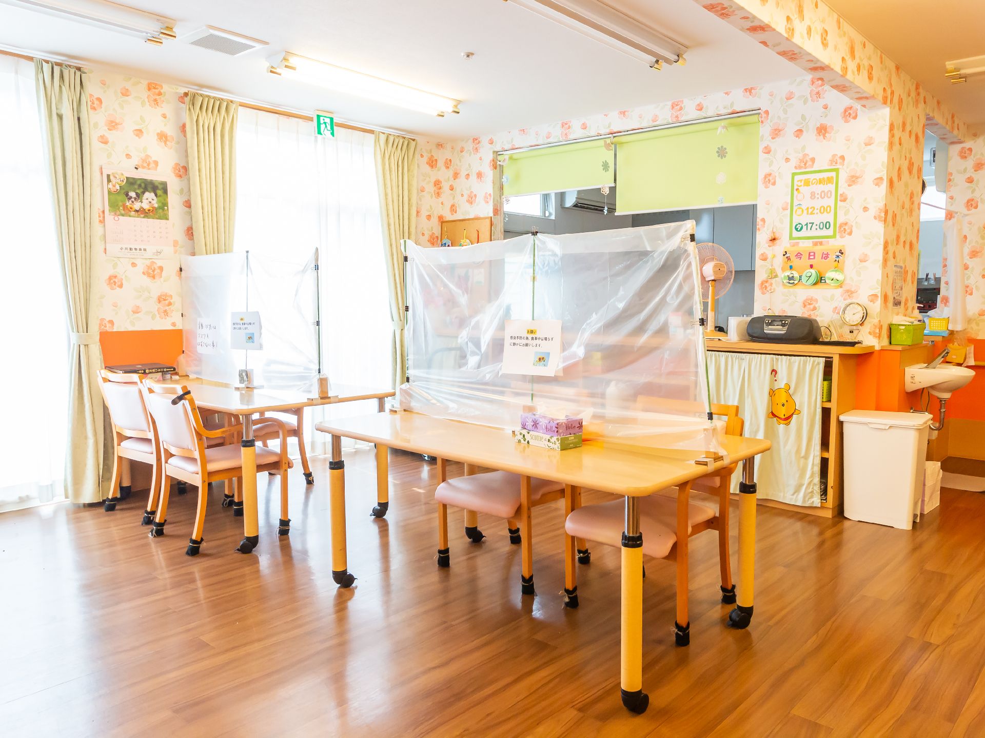 仕切りのついた木製の机が並んでいる広間