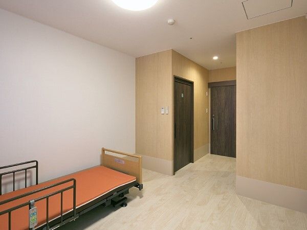 介護ベッドが置かれた部屋には家具などは持ち込まれていない。照明やスプリンクラーが天井についている。