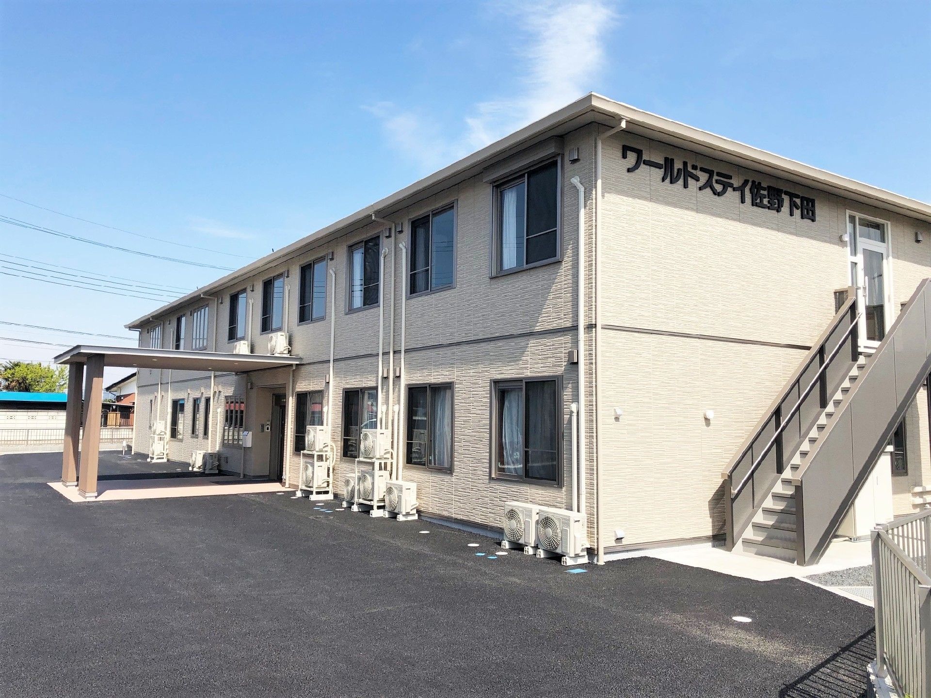 ２階建ての建物。ベージュを基調とし、２階には屋外階段が付き、外壁にはホーム名が書かれている。