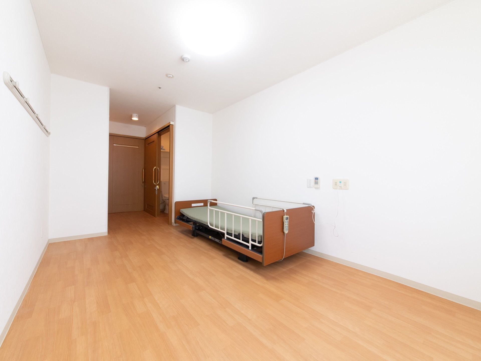 フローリングに白い壁の、シンプルで清潔感を感じさせる部屋である。大きな電灯は明るく、室内全体を明るく照らしている。