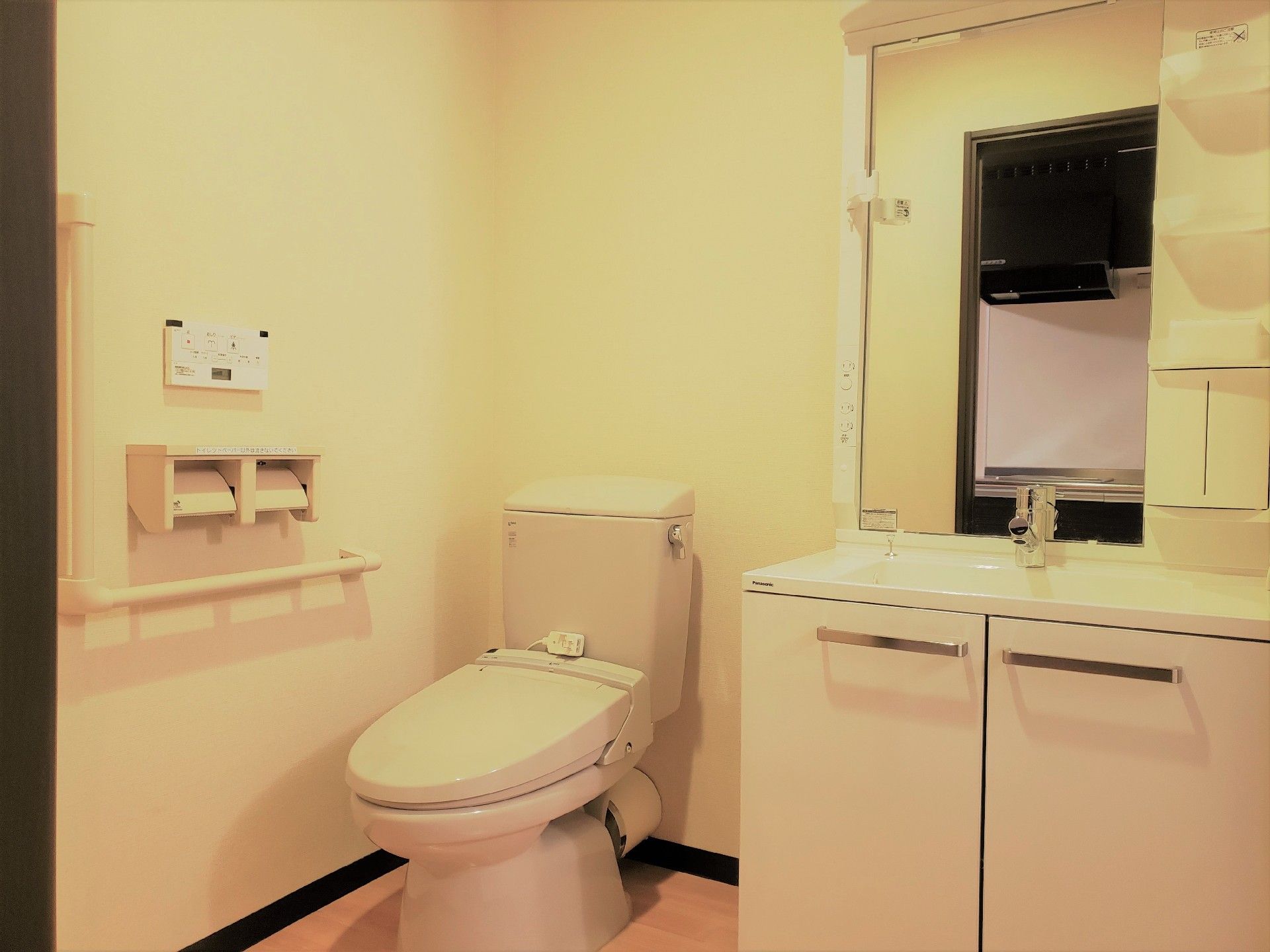 収納付きの洗面台がついたトイレの様子。ウォシュレットと緊急コールがあるトイレ