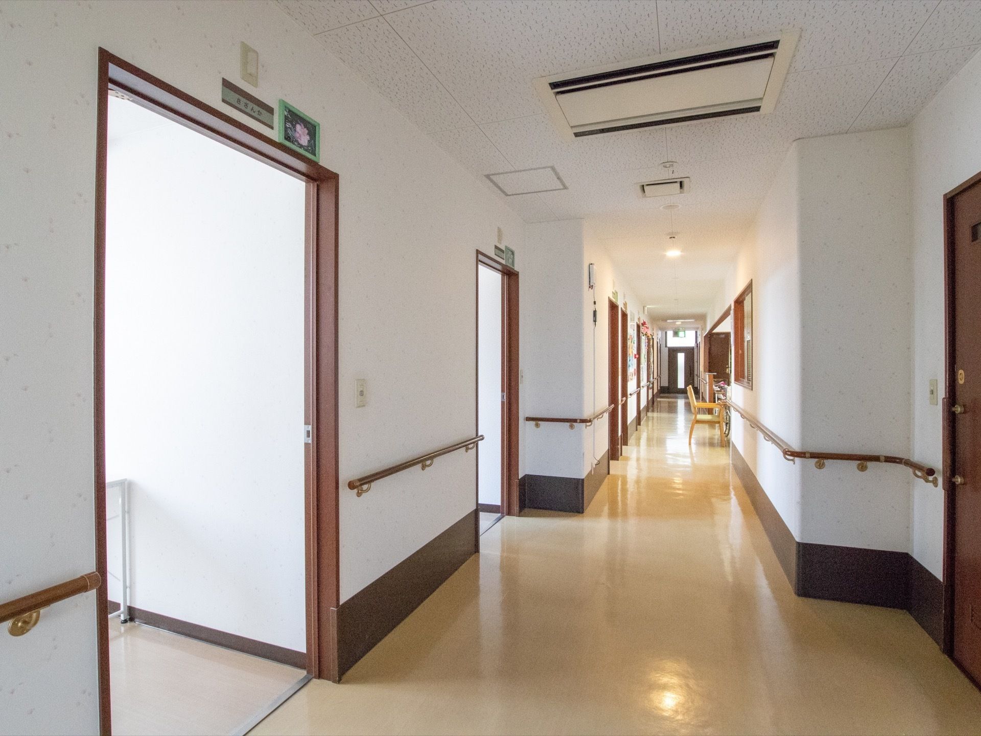 居室前の廊下である。幅が広く確保され、壁には手すりが設置され、スムーズな歩行や移動のための安全対策が取られている。