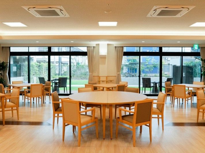 庭園を見ながら食事ができる食堂。デザインの異なるテーブルセットが室内と屋外に置かれている。
