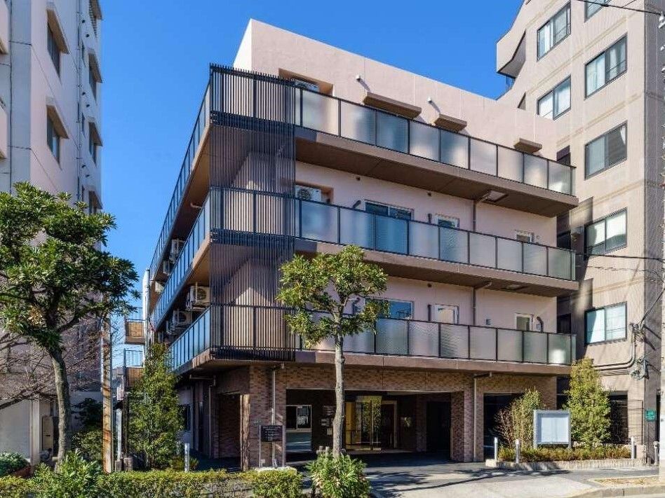 各フロアにベランダがあり、建物周辺には草木が植えられた住宅。４階建てでスタイリッシュなデザイン。