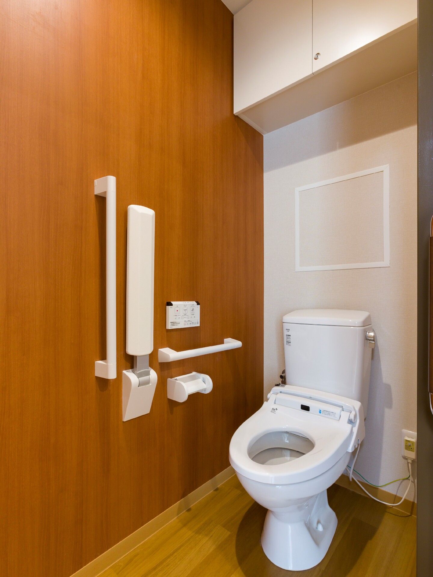 手すりとナースコールがついているトイレ。施設内の高齢者向けトイレの写真