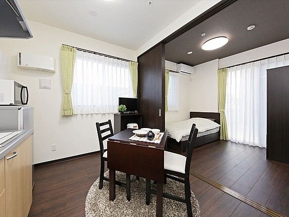 リビングセットと寝室が写っている様子。施設内の２部屋タイプの部屋の写真