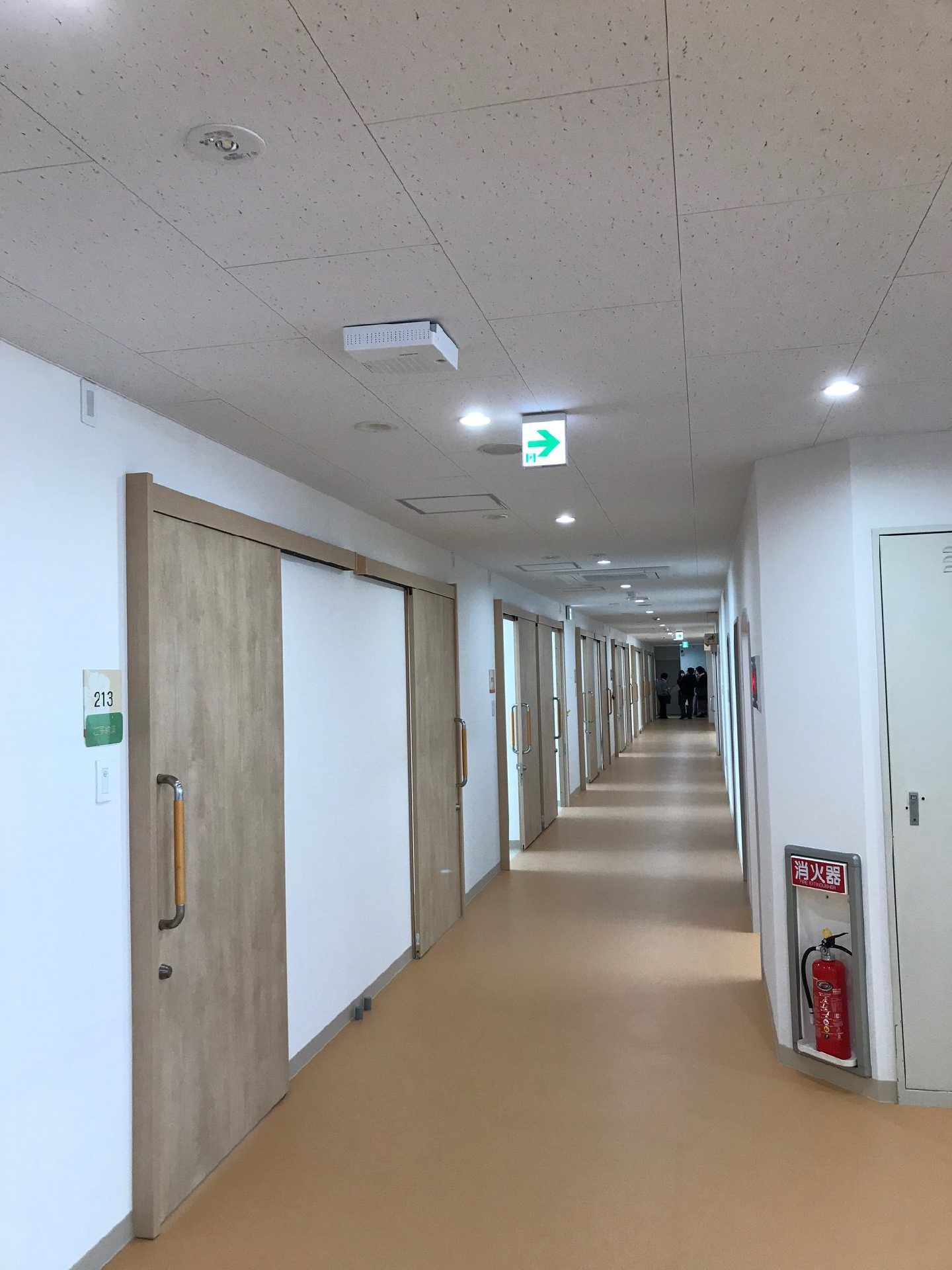 余計なものが置かれていないすっきりとした廊下。居室のドアは引き戸で、消火器も置かれている。