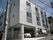 3階建ての建物はグレーで窓がたくさんつき、玄関部分は奥に入っていて段差がない。
