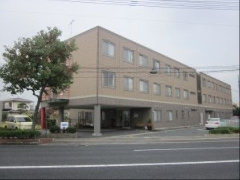 玄関前に吹き抜けの車寄せスペースがあり、敷地内には駐車スペースもある施設の外観
