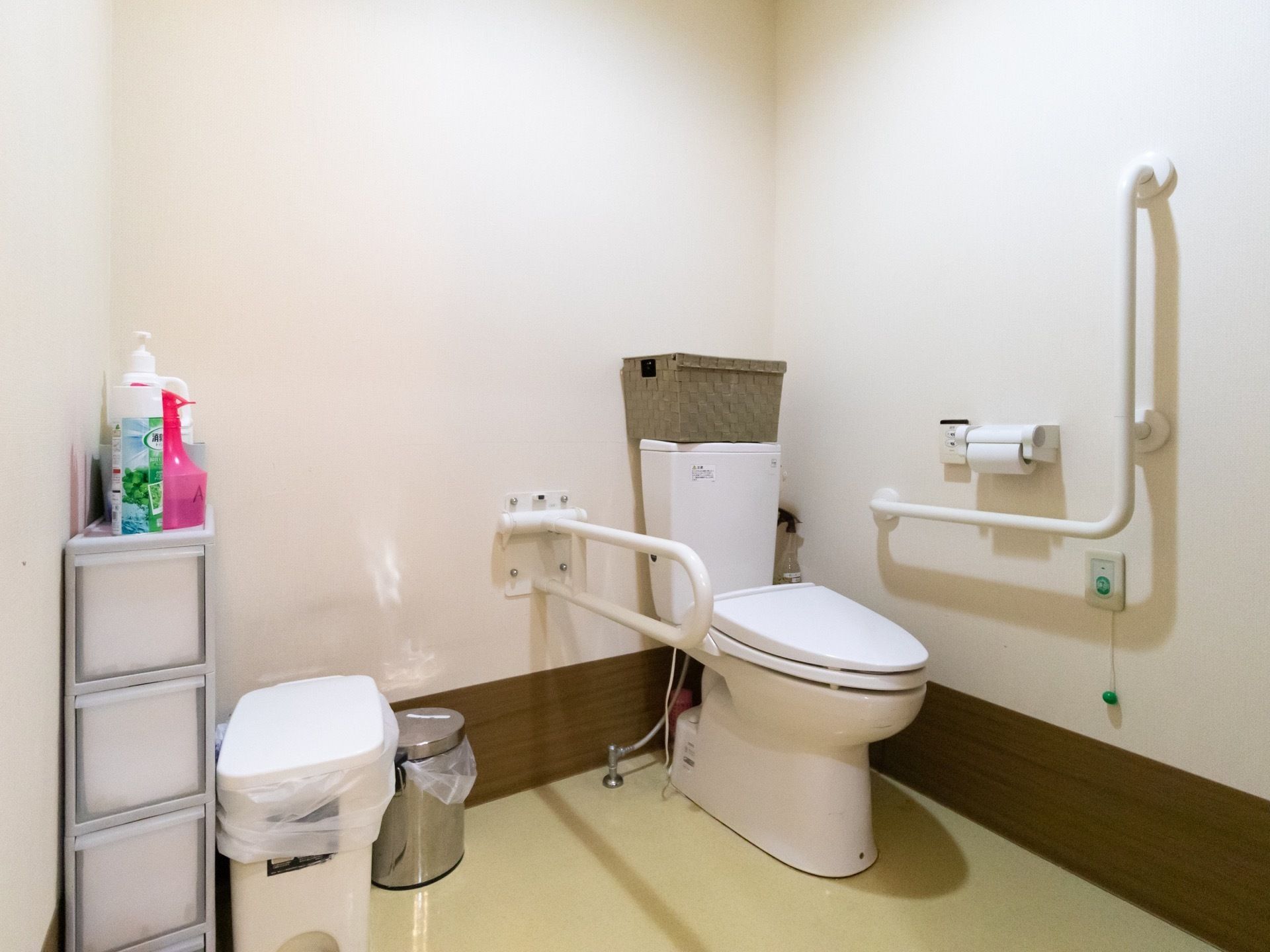 トイレには収納棚が設置されており、備品がスッキリと整理されている。安全のため、便器の周辺には手すりや安全バーなどを完備している。
