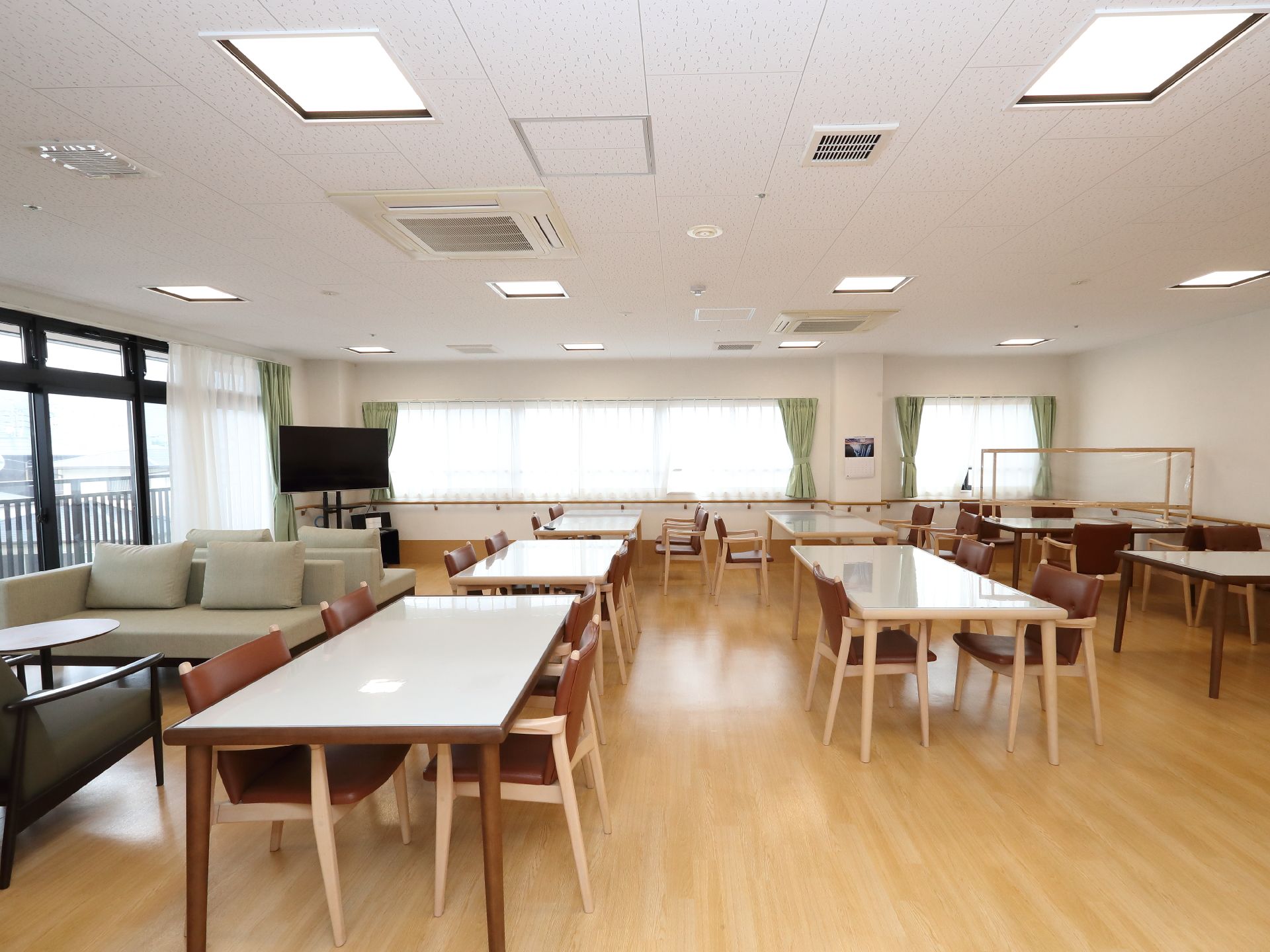 多くの椅子と長テーブルが設置された共有スペース