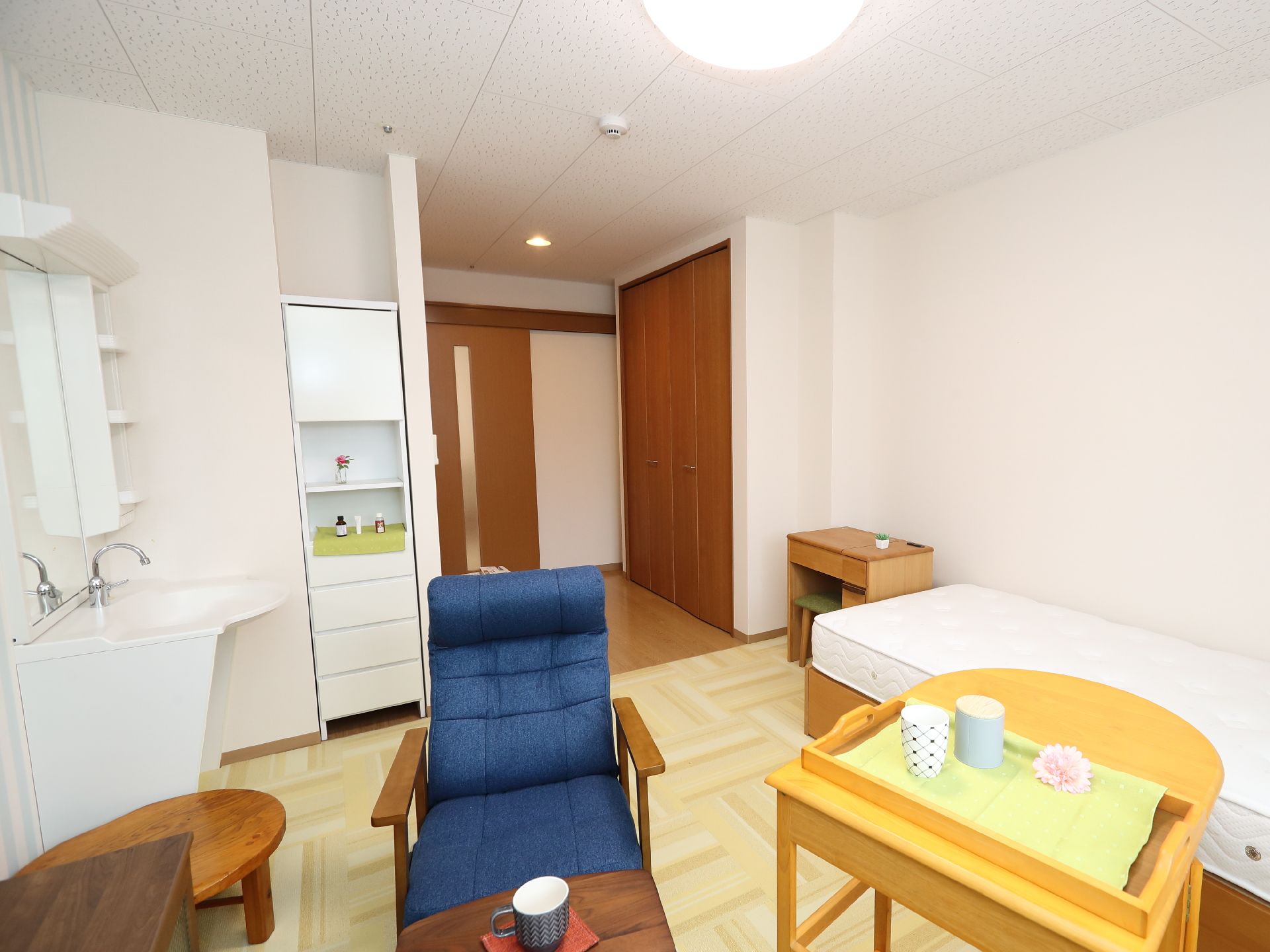 窓から日差しが差し込み、介護ベッドなどが置かれている居室