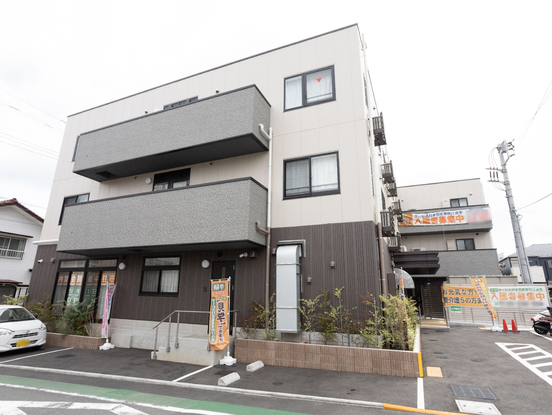1階部分がブラウン、2階以上がホワイトのモダンな外観