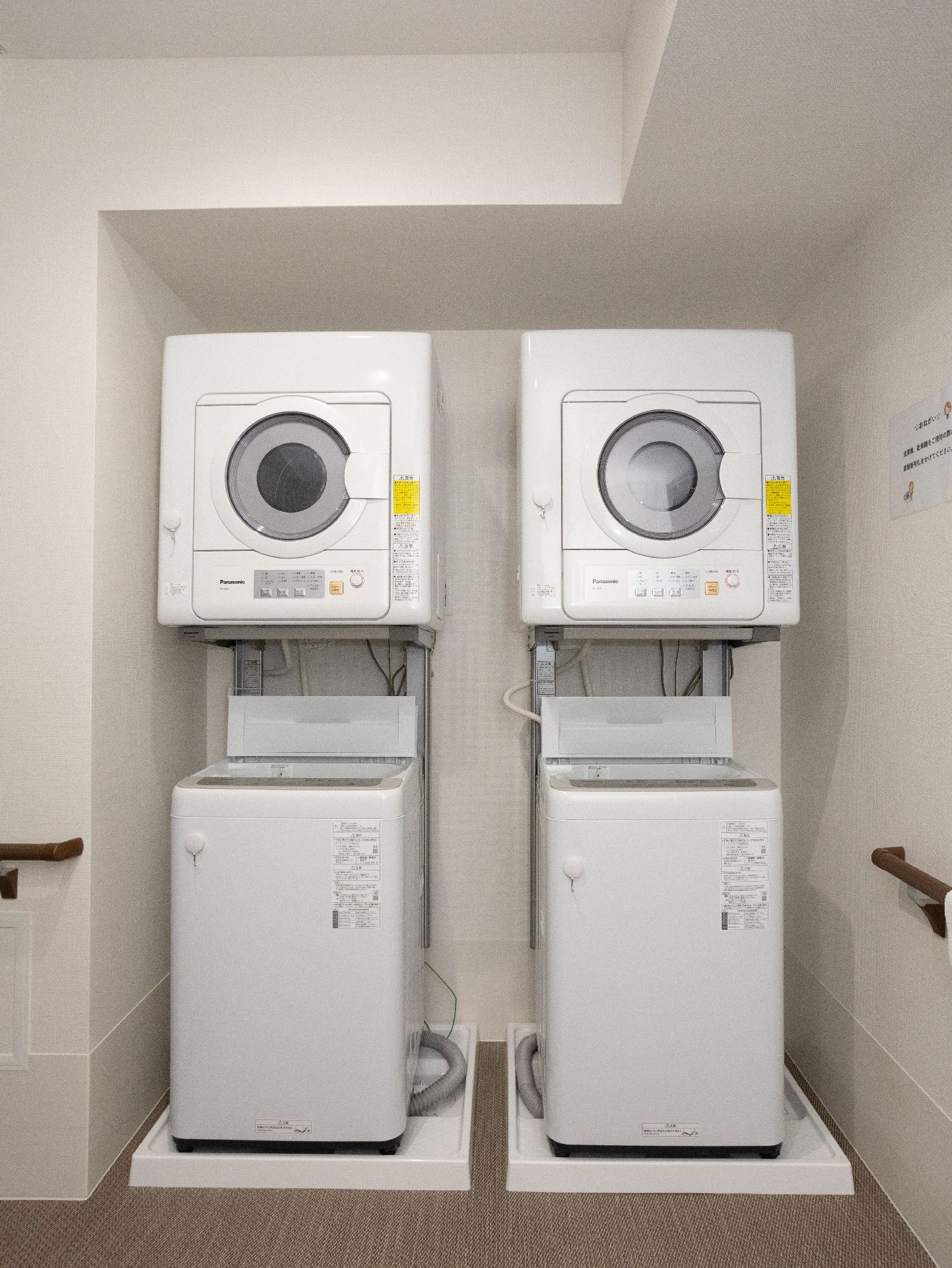 2つ並べて置かれている、入居者の衣類を洗濯するための洗濯機と乾燥機