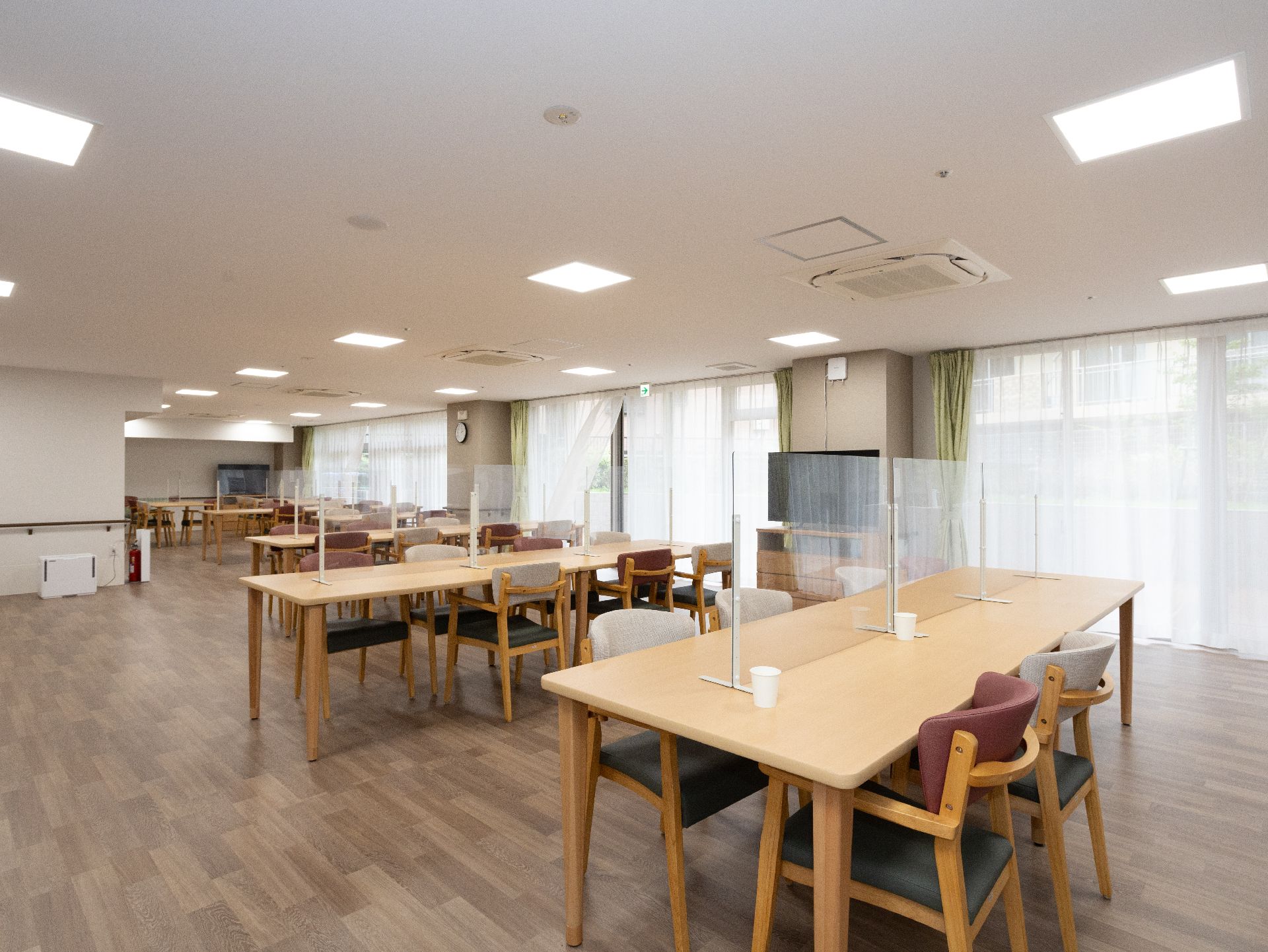 照明が多く取り付けられ、大きな窓も多数設置されている食堂
