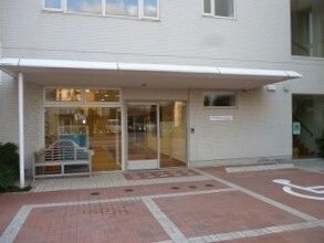 建物内で仕事をしているスタッフ。誰かに目線を合わせ、会話しようとしている。
