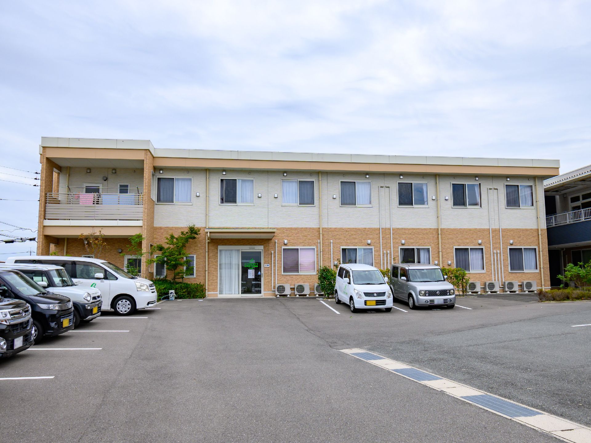 駐車場の出入り口から見た、斜め前から見た施設全体の外観