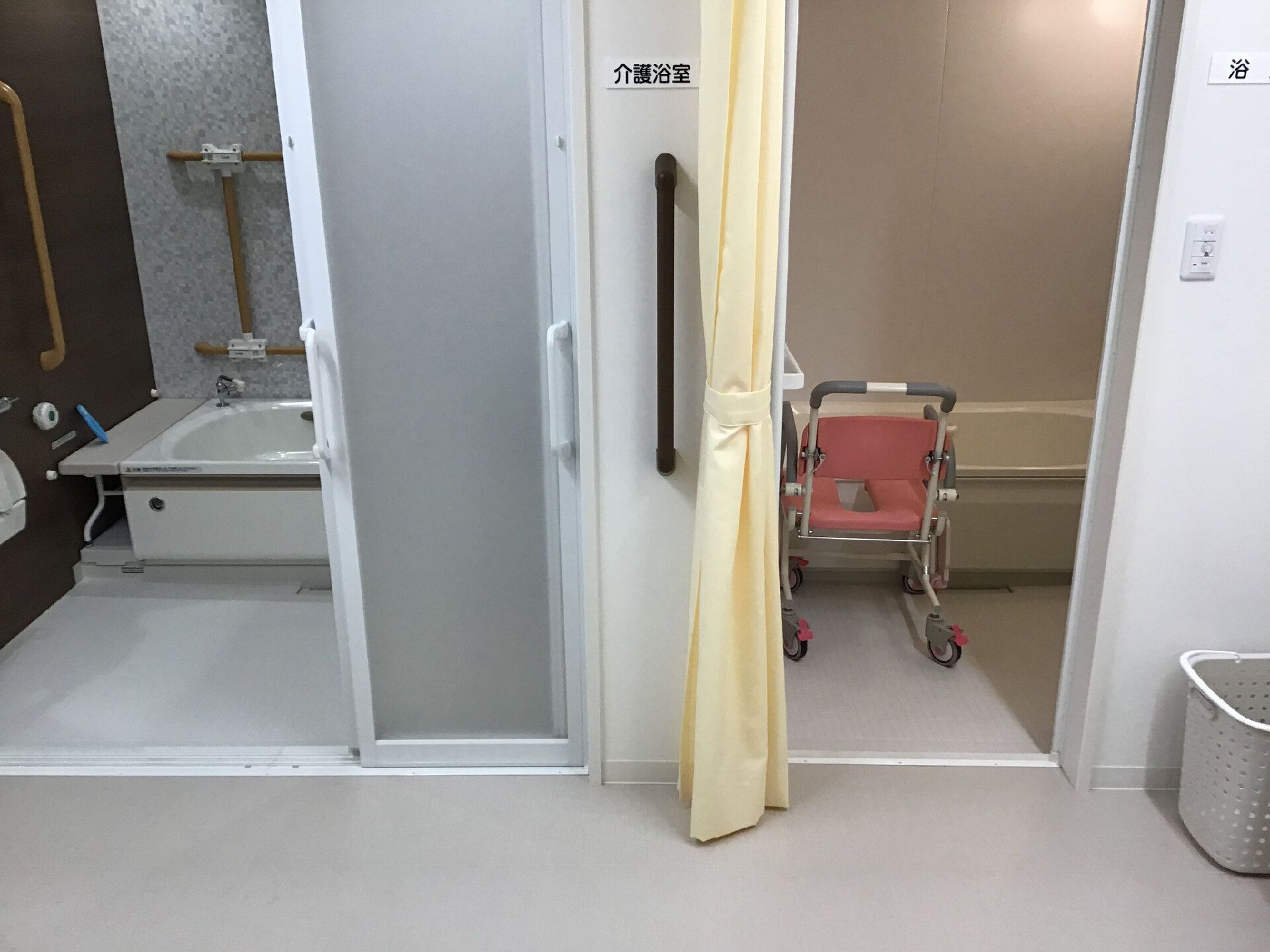 中央にカーテンがある脱衣所。浴室は左右に一つずつあり、それぞれデザインが異なるがどちらも一人用。