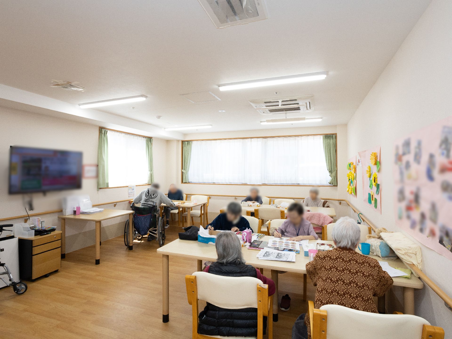 大きなテレビが設置され、入居者が自由に時間を過ごしているリビング
