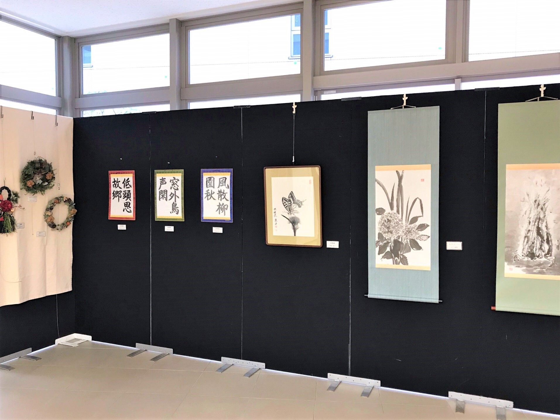 書道や絵が飾られている施設内のイベントの様子。リースや飾りもある様子