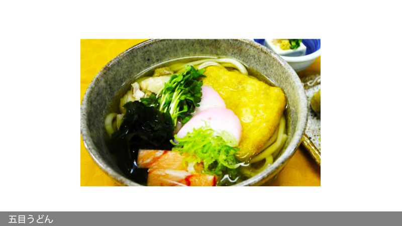 かいわれやワカメ、かまぼこ、カニカマ、揚げをトッピングした五目うどん