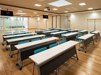 長机と椅子が複数並べられた会議室のような雰囲気の部屋