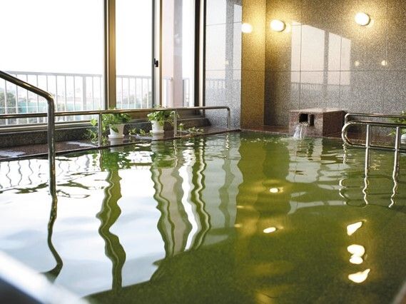手すりがついたプールのような雰囲気の大浴場の様子。施設内の大きな浴室