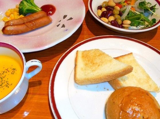 洋風の朝ごはんメニューの写真。パンやスープ、ソーセージなどが載っている様子