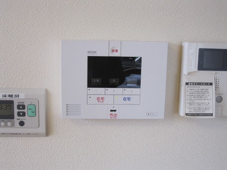 白い壁には警備会社のモニター付きのシステムやインターホン、床暖房のスイッチなどが設置されている。