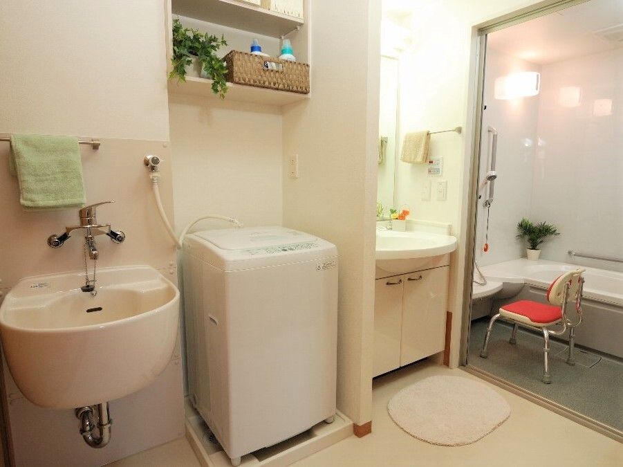 洗濯機や洗面所などが設置された脱衣所は広く、浴室にはシャワーチェアや手すりが付いている。