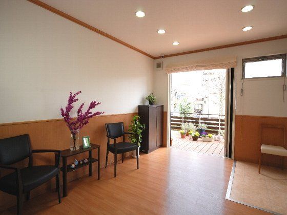 手前には黒いテーブルセットが置かれた共有スペースがあり、そこから屋外に設置されたウッドデッキのテラスに続いている。