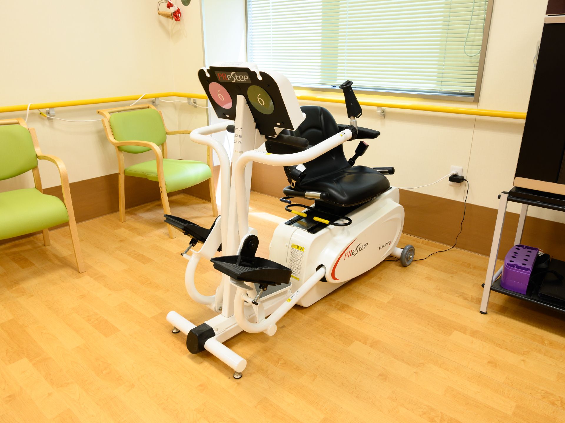 手すりが付いた白い壁の部屋に置かれたトレーニングマシーン