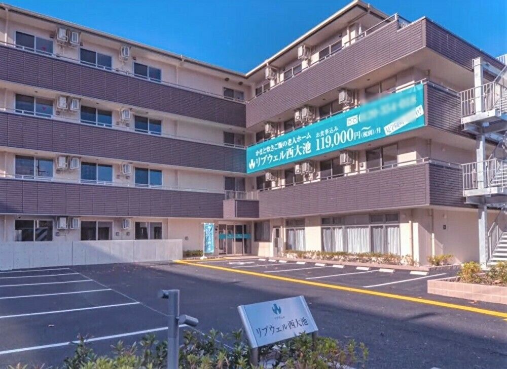 一人でくつろいでいる様子の高齢者。新聞を読みながら飲み物を飲んでいる様子