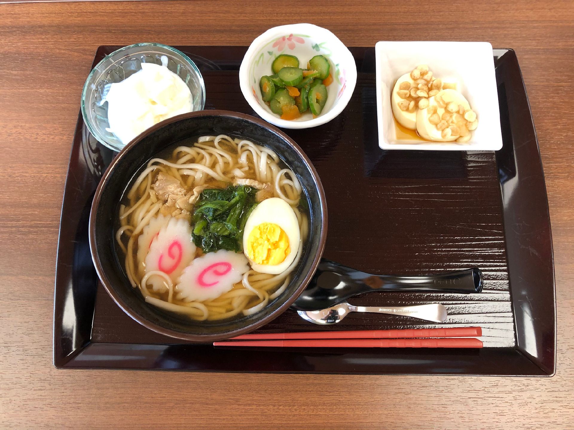 ゆで卵やなるとののったうどんと、小鉢が付いた食事