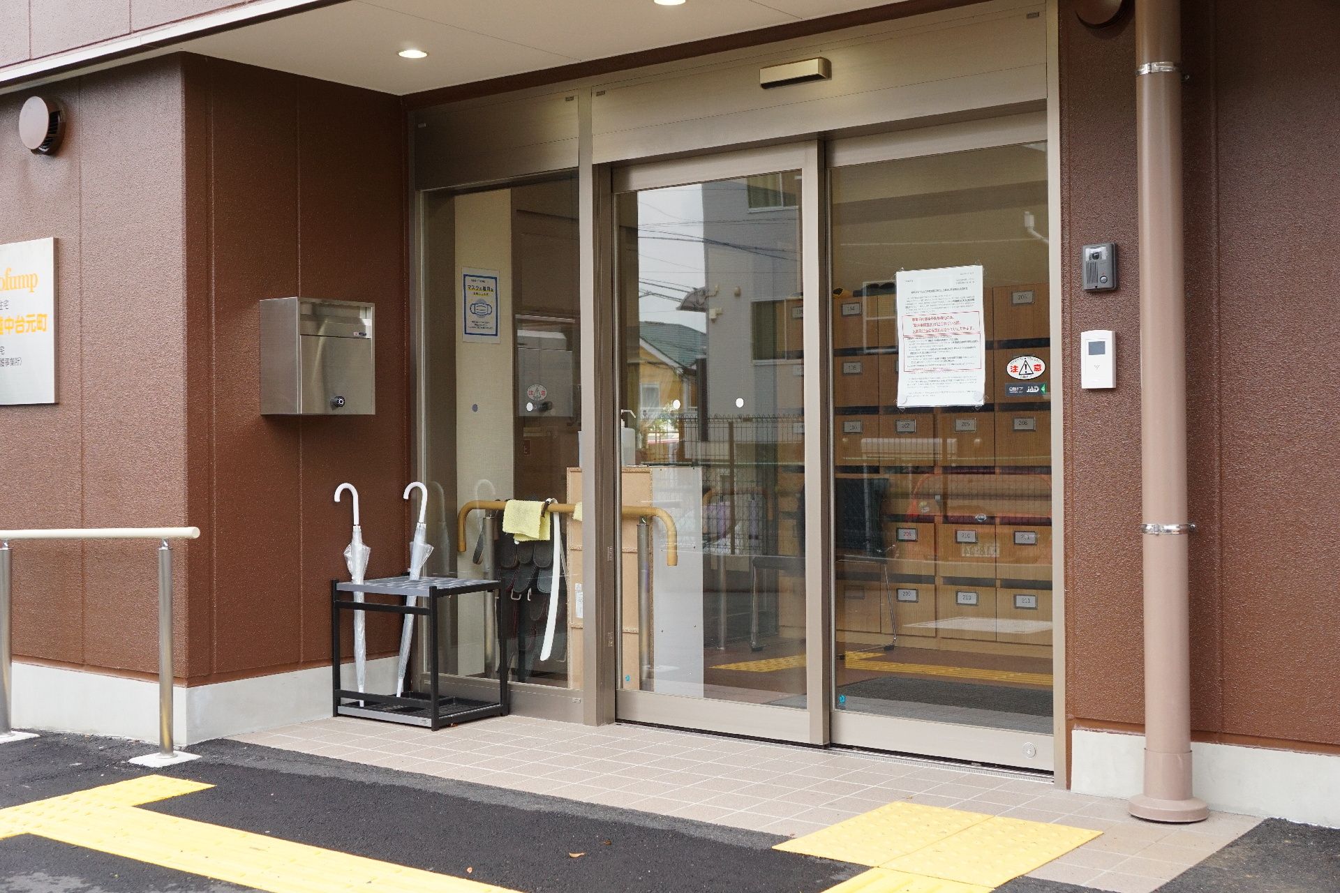 金属製の大きな手すりが取り付けられ、段差が解消されている玄関部分