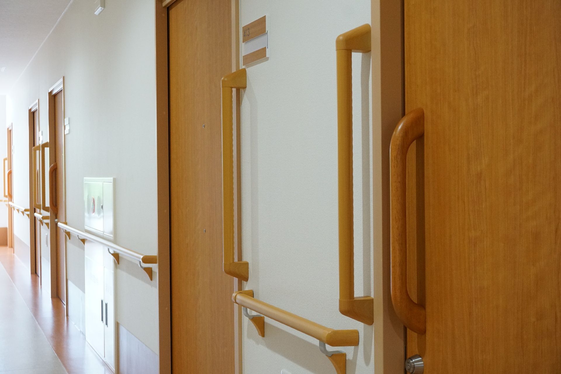 居室のドアを開けやすくするための手すりが設置されている廊下