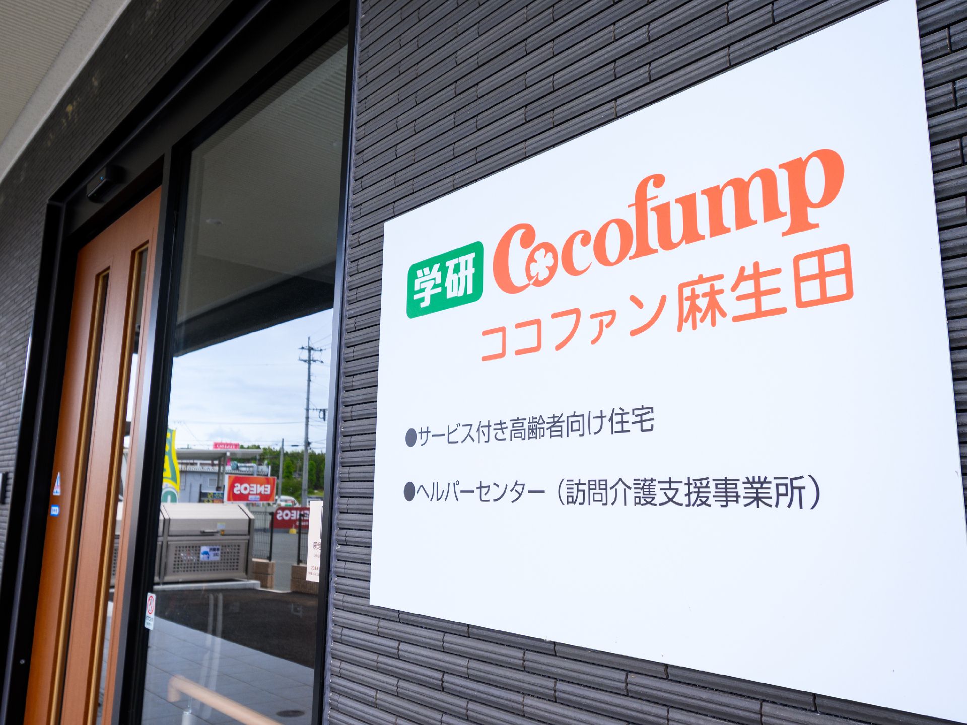 玄関ドアの横に設置されている施設の名称・ロゴが書かれた看板