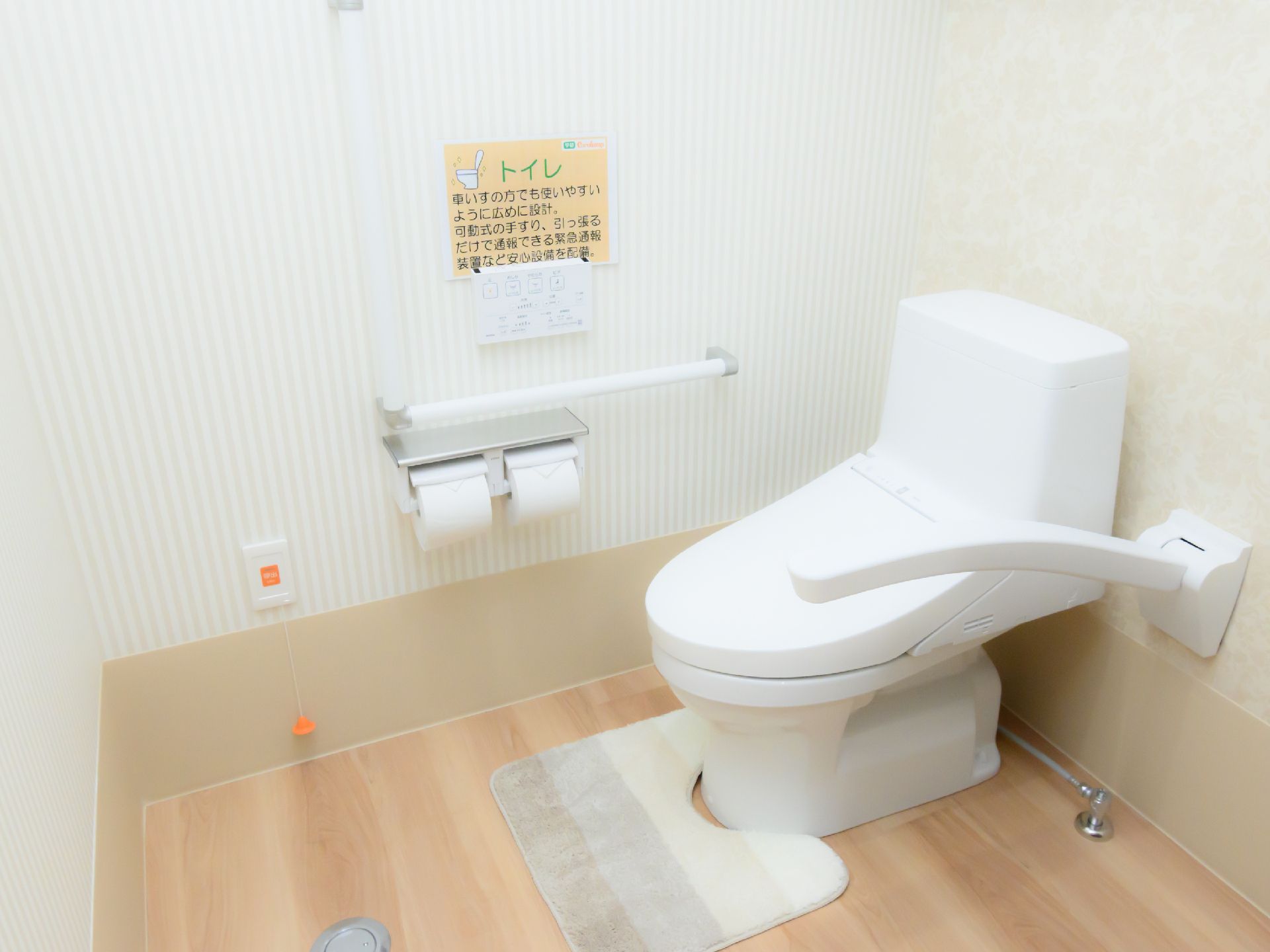 バリアフリー完備で、壁に手すりが設置されているトイレ