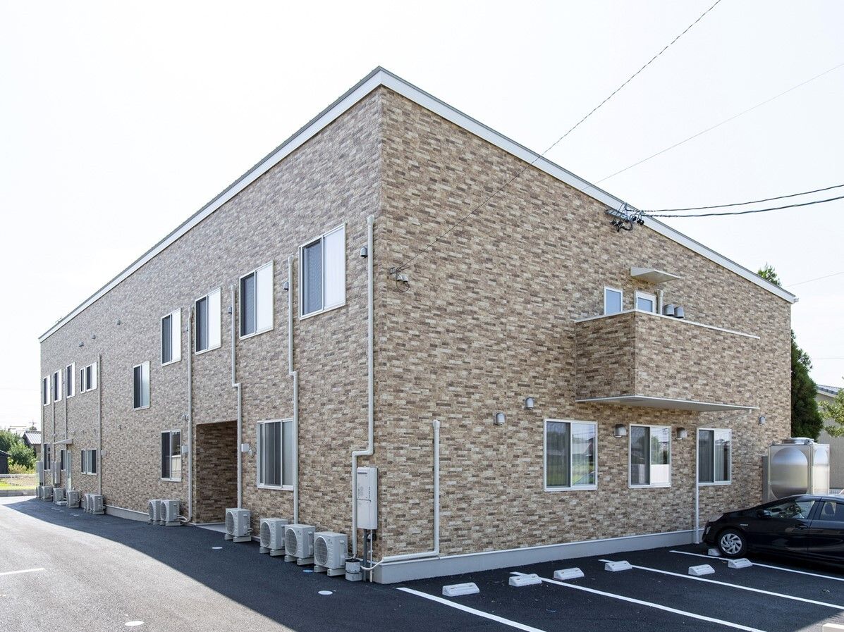 駐車スペースがついた敷地内には2階建てもの四角い建物が建っていて、2階部分にはベランダもある。周りに背の高い建物がなく日当たりも良好。
