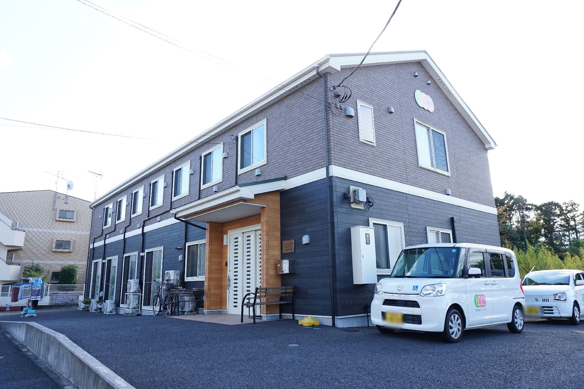 2階建てで、グレーを基調とした落ち着いた色が特徴的な施設の外観