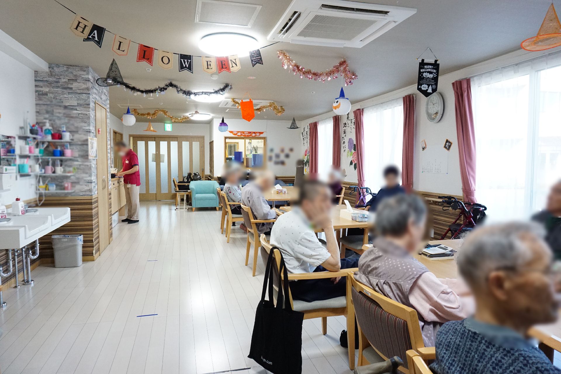 赤い車椅子に乗った高齢女性と介助をする女性ヘルパー