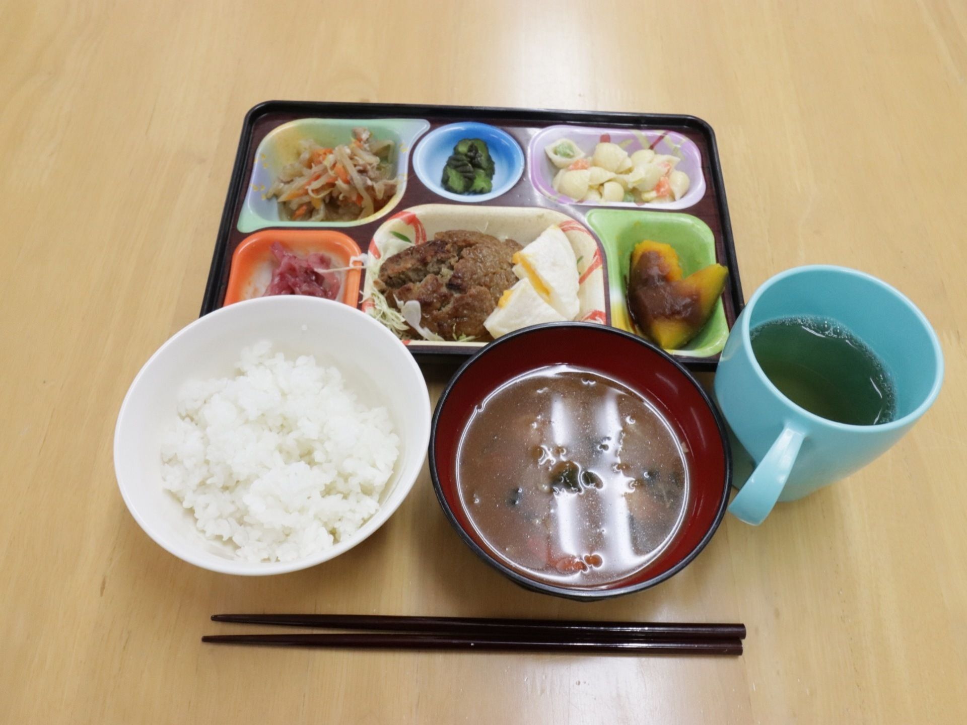 ハンバーグなどの主菜、副菜、ごはん、みそ汁が付いた食事を提供している。野菜をたくさん摂ることができる献立になっている。