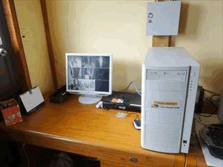 木製のテーブルの上にはパソコンが置かれ、モニターが9つの画面に分かれ、館内の様子が映し出されている。