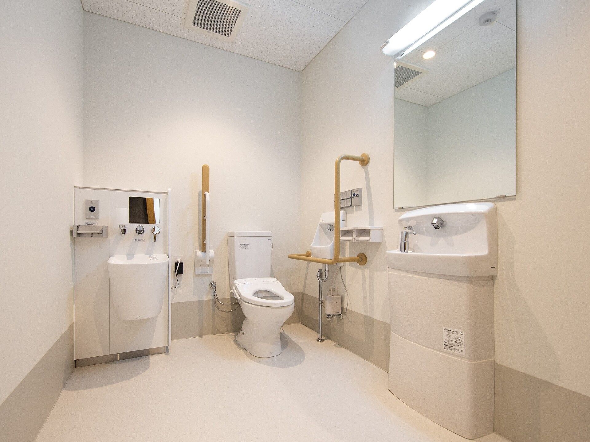 オストメイト対応のトイレは広く、手洗い場にも大きな鏡が付き、トイレの両サイドには手すりがある。