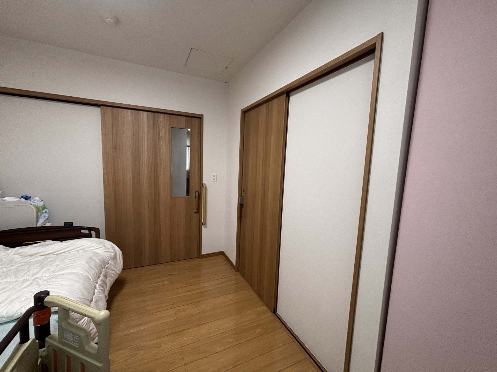木製ドアとベッドの部屋