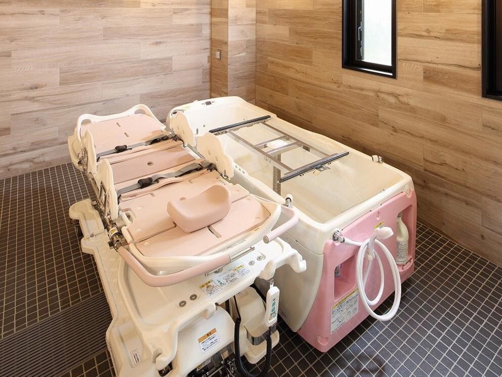 ピンク色の、寝たままの状態でそのまま湯につかれる浴槽