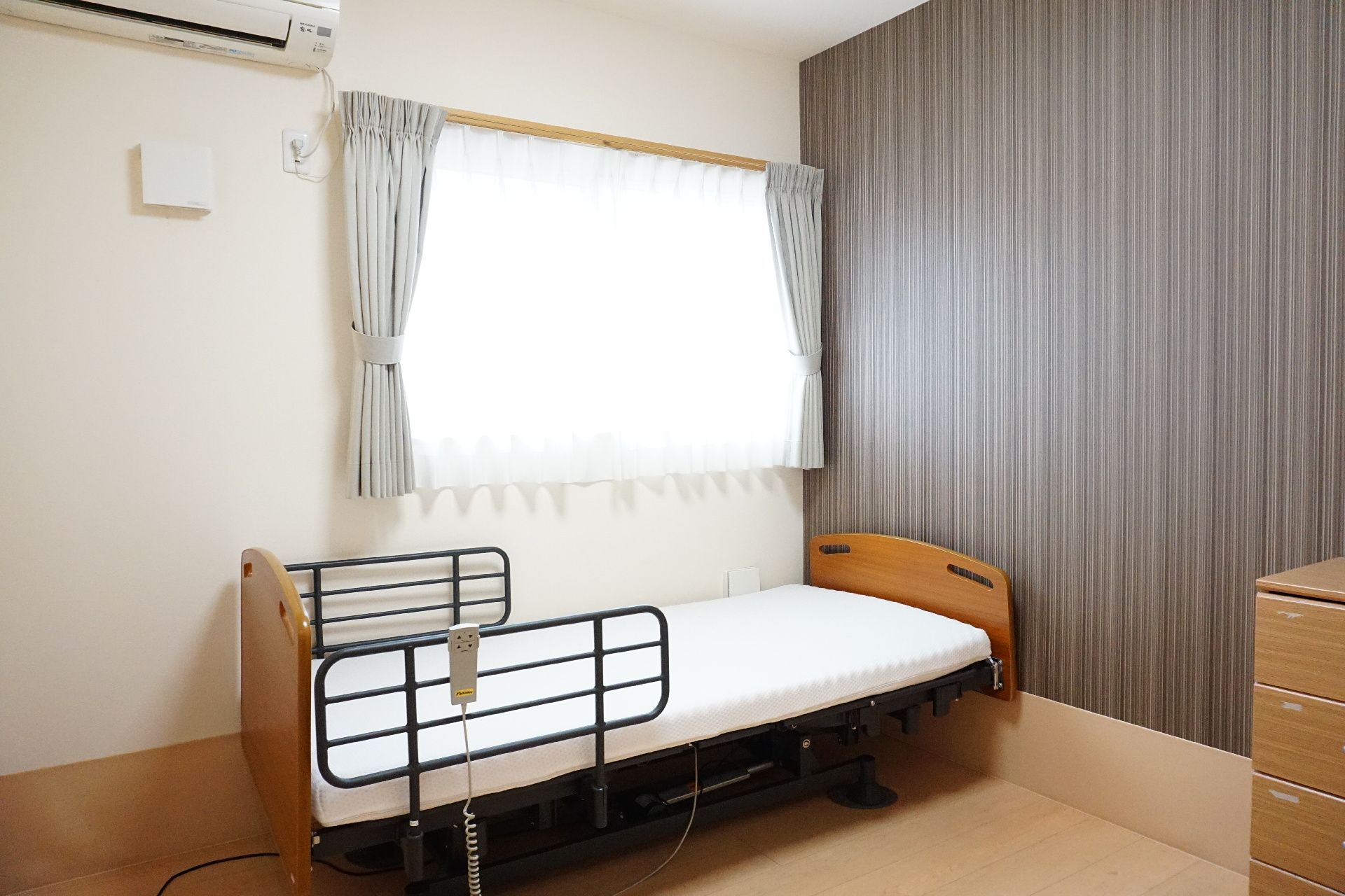 窓から日差しがでて込み、介護ベッドが置かれている居室